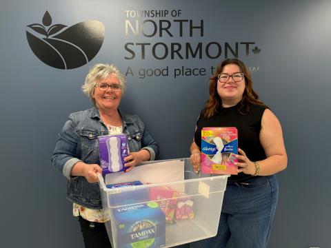Olivia Leroux, United Way SDG representative and Carol Hunt from the Township of North Stormont holding a box of menstrual products as part of the Period Promise Campaign